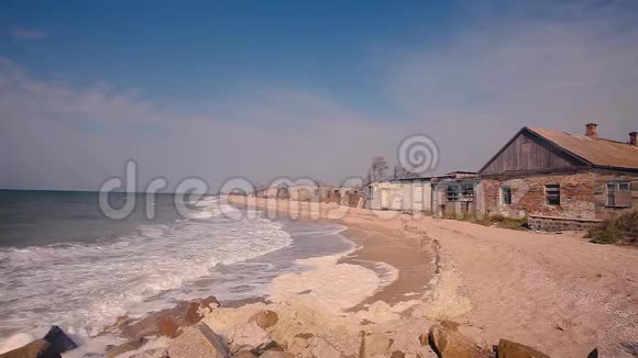 海岸上的建筑被毁海边的秋意沙滩上的波浪翻滚视频的预览图