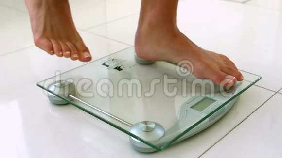 体重秤上的女性脚视频的预览图