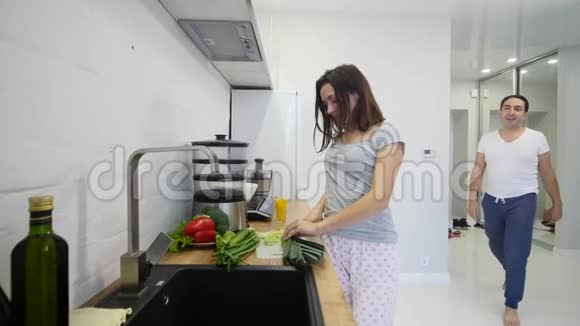 爱的男人一大早就在厨房里拥抱他微笑的女朋友早餐是慢动作做的视频的预览图