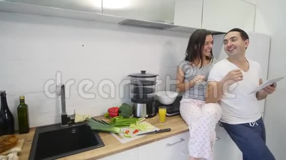 家庭厨房里有平板电脑的幸福夫妻视频的预览图