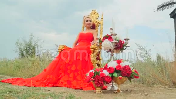 穿着红色裙子坐在金色宝座上的女孩视频的预览图