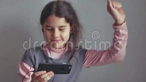 少女听耳机音乐在智能手机上跳舞视频的预览图