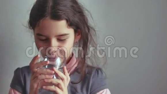 少女从室内的杯子里喝水视频的预览图