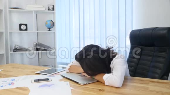 疲惫的女商人睡在桌子上视频的预览图