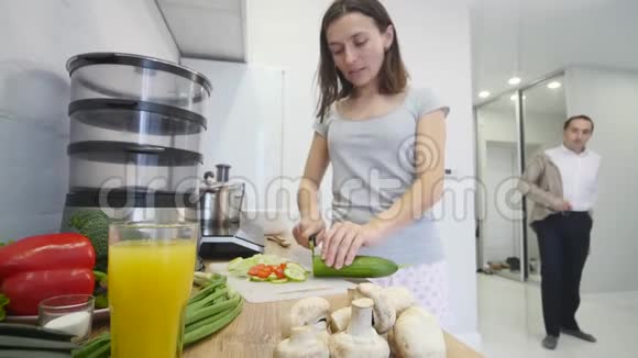 有爱心的男人一大早就在厨房里抱着他微笑的女朋友做早餐视频的预览图