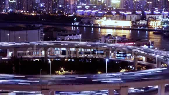时间流逝城市交通的光迹在立交桥上航运在河流上视频的预览图