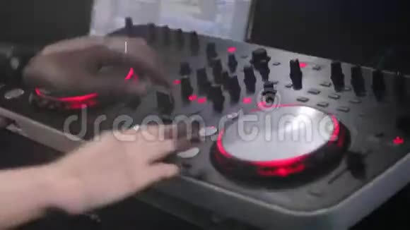 DJ在一家夜总会里玩遥控器DJ控制台的特写视频的预览图