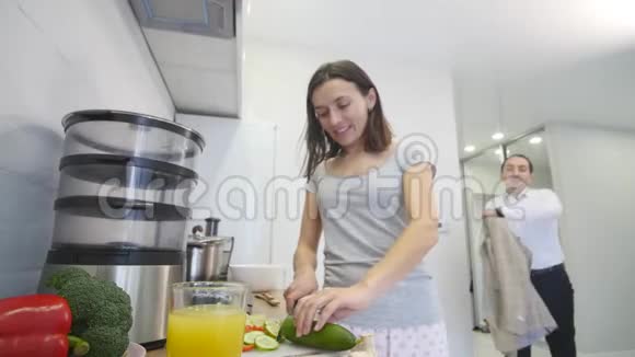 有爱心的男人一大早就在厨房里抱着他微笑的女朋友做早餐视频的预览图