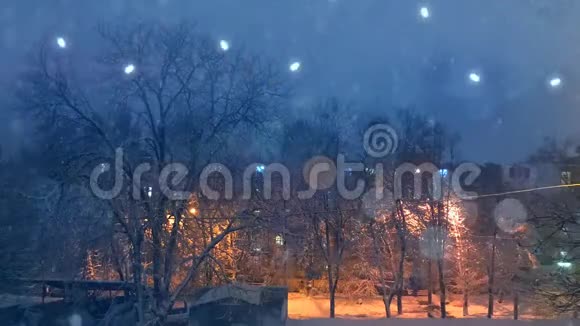 平面图外面院子里的冬天天气下着雪前景上有快乐的灯光视频的预览图