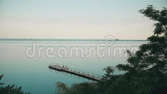 木码头和渔人独揽湖畔日出景观视频的预览图