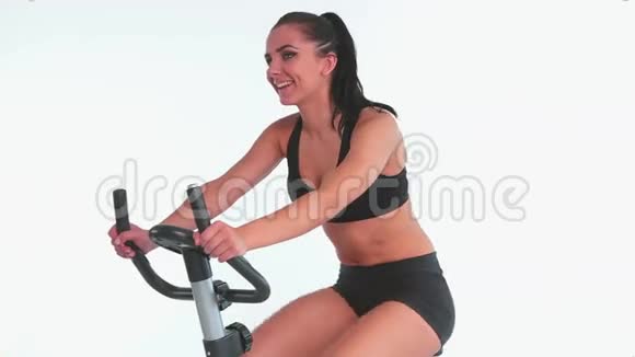 活泼开朗的黑发女人用运动自行车视频的预览图