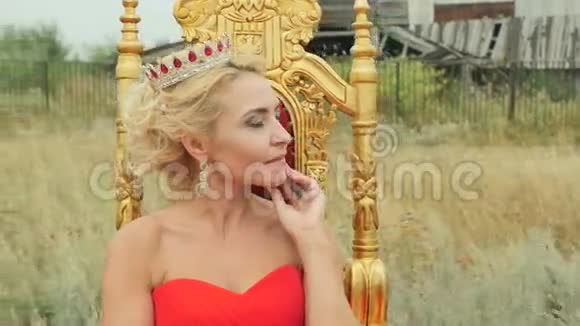 穿着红色裙子坐在金色宝座上的女孩视频的预览图