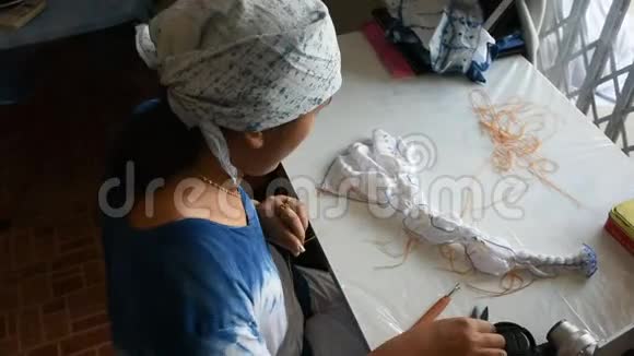 泰国妇女的工作过程是在织物上折叠成捆或缝制视频的预览图