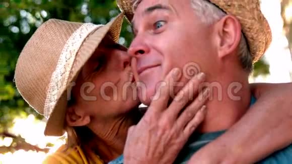 在阳光明媚的一天一位年长的女士亲吻她的伴侣视频的预览图