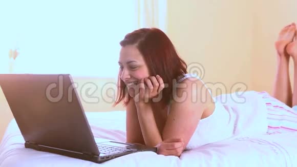 快乐的女人在笔记本电脑上看电影视频的预览图