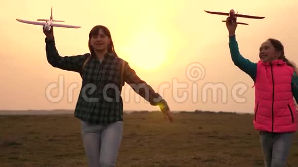孩子们玩玩具飞机青少年想成为飞行员和宇航员日落时分快乐的女孩在玩具飞机上奔跑视频的预览图