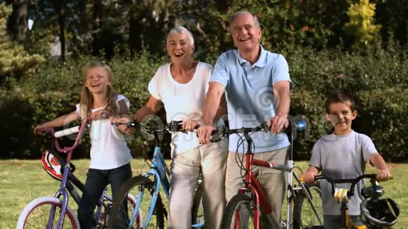 一家人骑着自行车站在公园里视频的预览图