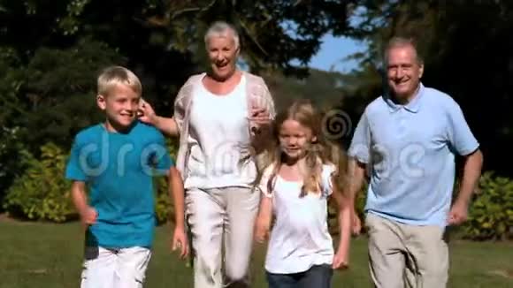 祖父母和他们的孙子在公园里跑步视频的预览图