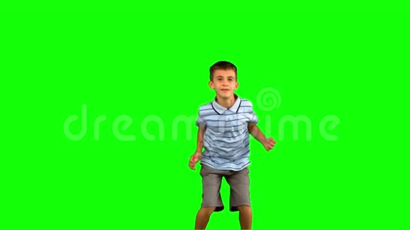 小男孩在绿色的屏幕上跳跃视频的预览图