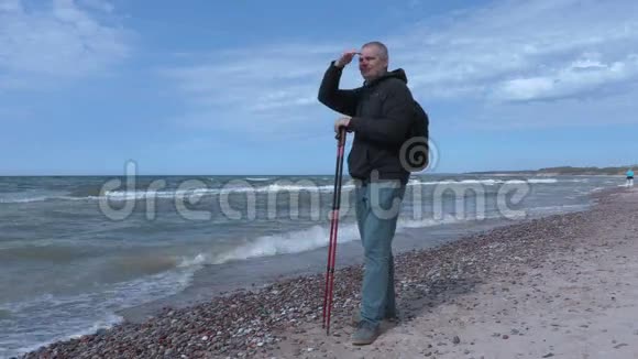 带着登山杖在海边的人视频的预览图