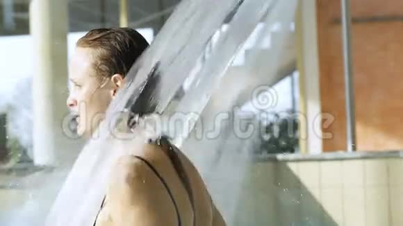 在游泳池里享受强力淋浴的女人视频的预览图