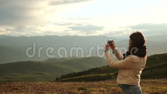 女徒步旅行者用智能手机拍照山顶悬崖视频的预览图