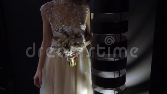 穿着婚纱的年轻新娘在室内捧着花束白色豪华礼服视频的预览图