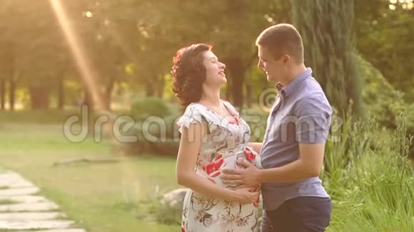 日落时和丈夫在一起的孕妇视频的预览图