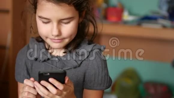 青少年女孩在网上玩你的智能手机视频的预览图