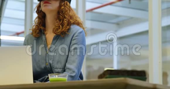办公桌4k上使用虚拟现实耳机的女商人视频的预览图