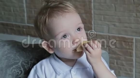 一个金发小男孩在厨房吃圆片视频的预览图