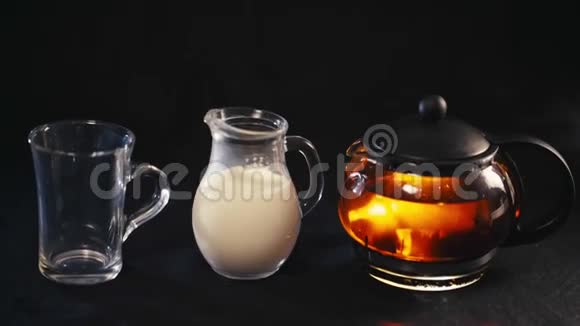 玻璃杯里的茶透明杯里的茶和一小壶牛奶视频的预览图