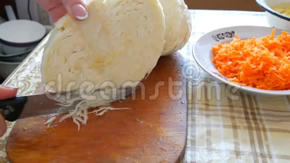 厨房里的女人把卷心菜切得很近在厨房用木板做的白色卷心菜视频的预览图