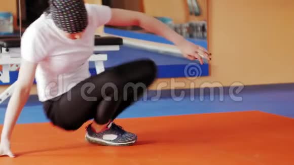 一个有魅力的女人在运动健身房的模拟器上做伸展运动视频的预览图
