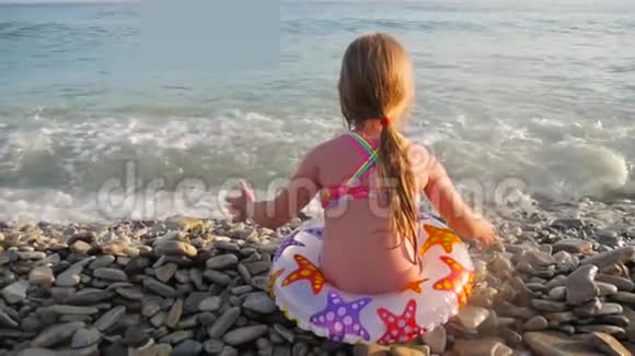 小女孩在海滩上快乐地玩波浪视频的预览图