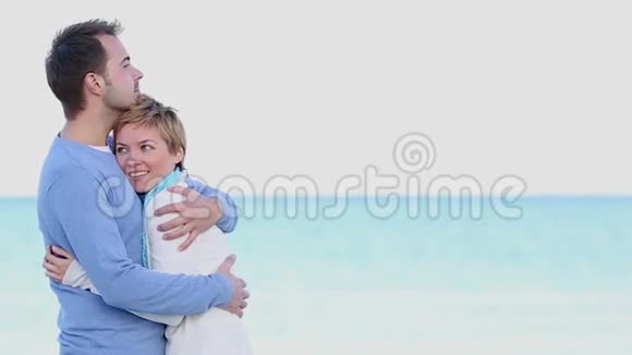 美丽的年轻夫妇拥抱在海滩上视频的预览图
