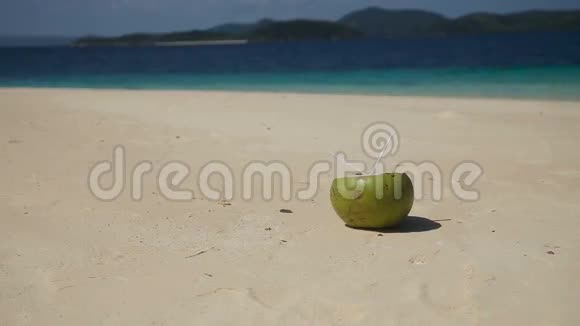 在海沙上放着吸管的椰子视频的预览图