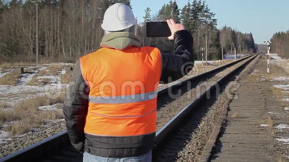 铁路员工在铁路上用平板电脑拍摄视频的预览图