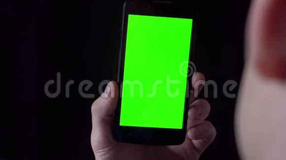 穿着衬衫的年轻人拿着手机面前有绿色屏幕视频的预览图