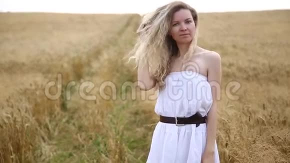 金色田野上的金发美女肖像视频的预览图