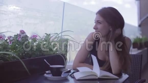 坐在街头咖啡馆里写笔记的漂亮女孩视频的预览图