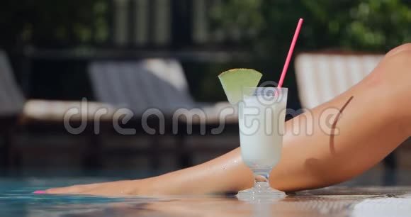游泳池边的漂亮女人腿和鸡尾酒视频的预览图