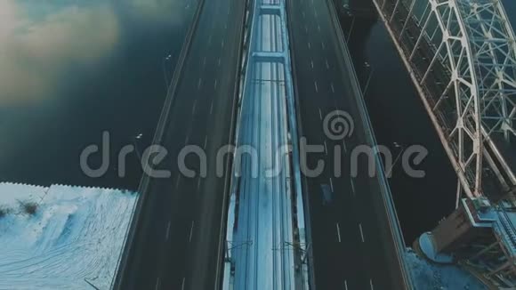 汽车和火车在结冰的河流上空的无人机画面上行驶视频的预览图