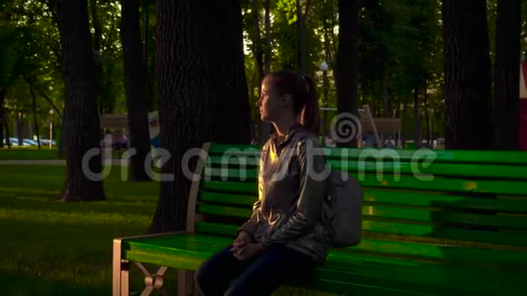 坐在公园长椅上的女人视频的预览图