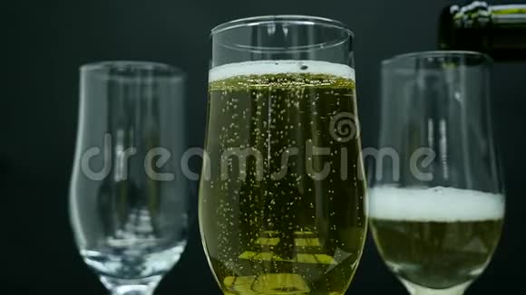 带有气泡的香槟倒入黑色背景的玻璃杯中视频的预览图