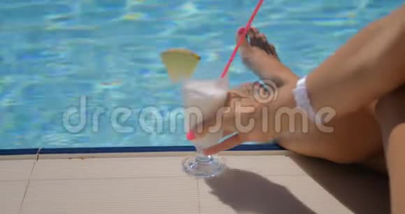游泳池边的漂亮女人腿和鸡尾酒视频的预览图