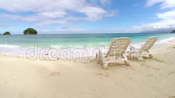 空中飞行两把空椅放在海边的海滩上视频的预览图