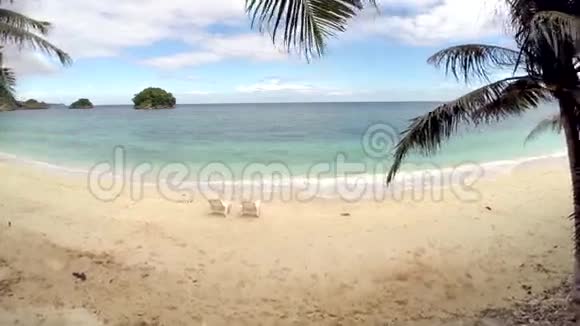 空中飞行两把空椅放在海边的海滩上视频的预览图