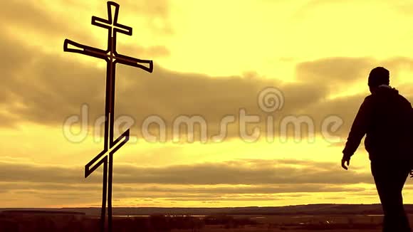 山顶上的剪影人满怀希望地看着基督教十字架一个向十字架忏悔的人背景视频的预览图