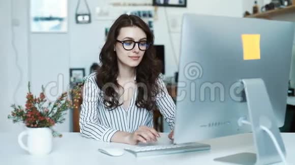 快乐的西班牙裔年轻女性在办公室或学校使用平板电脑视频的预览图
